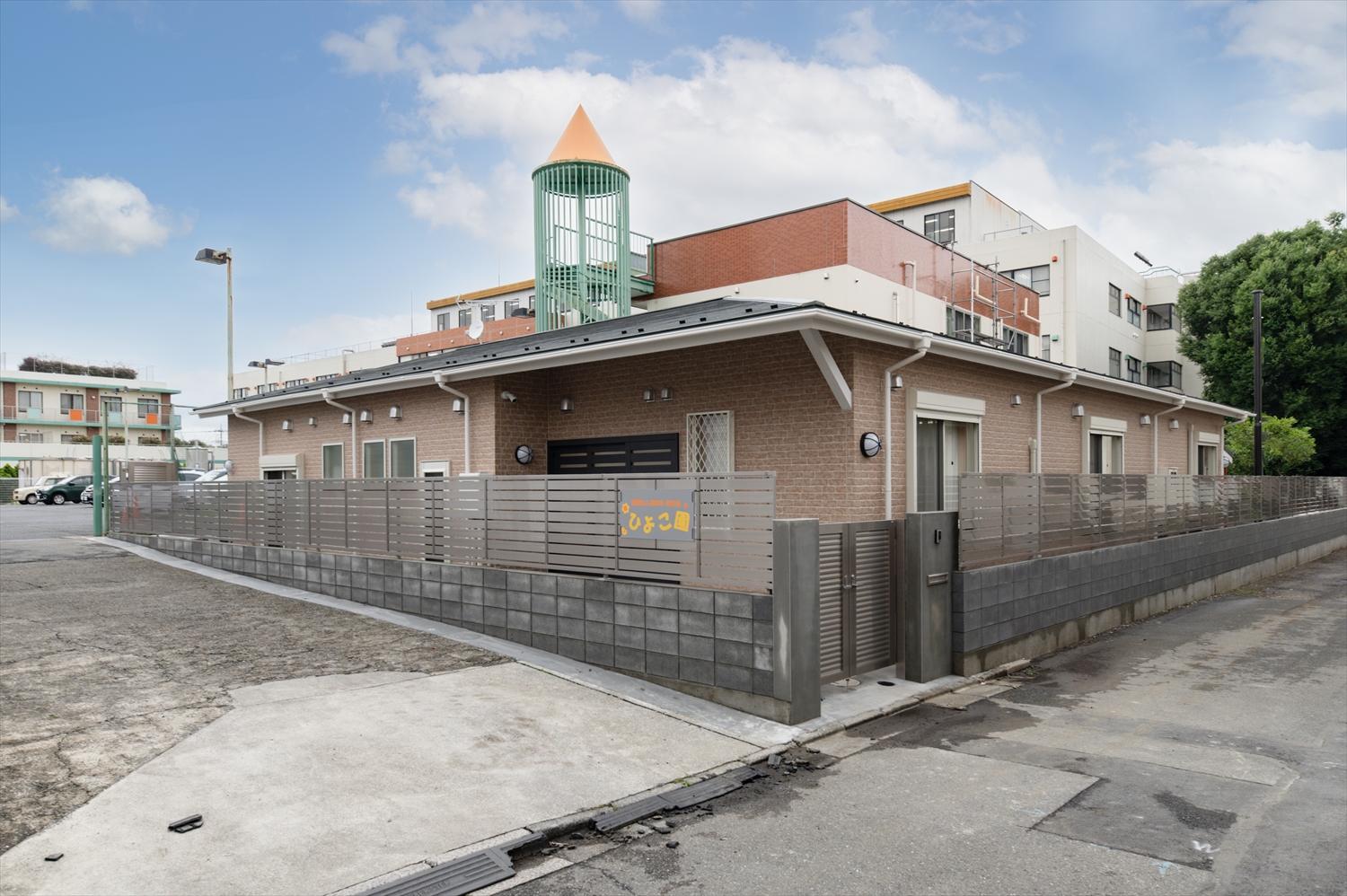 院内保育園の外観写真。レンガ調の建物と高いフェンスに囲まれた安心感のある保育施設。