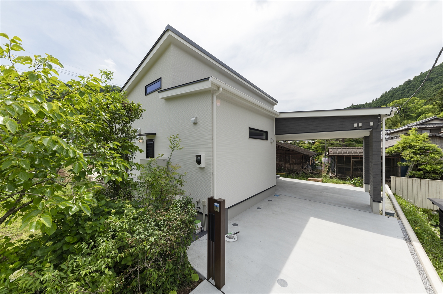 テクノストラクチャー工法で建築された、白い外壁と駐車場付き平屋住宅の外観写真（自然環境と調和）