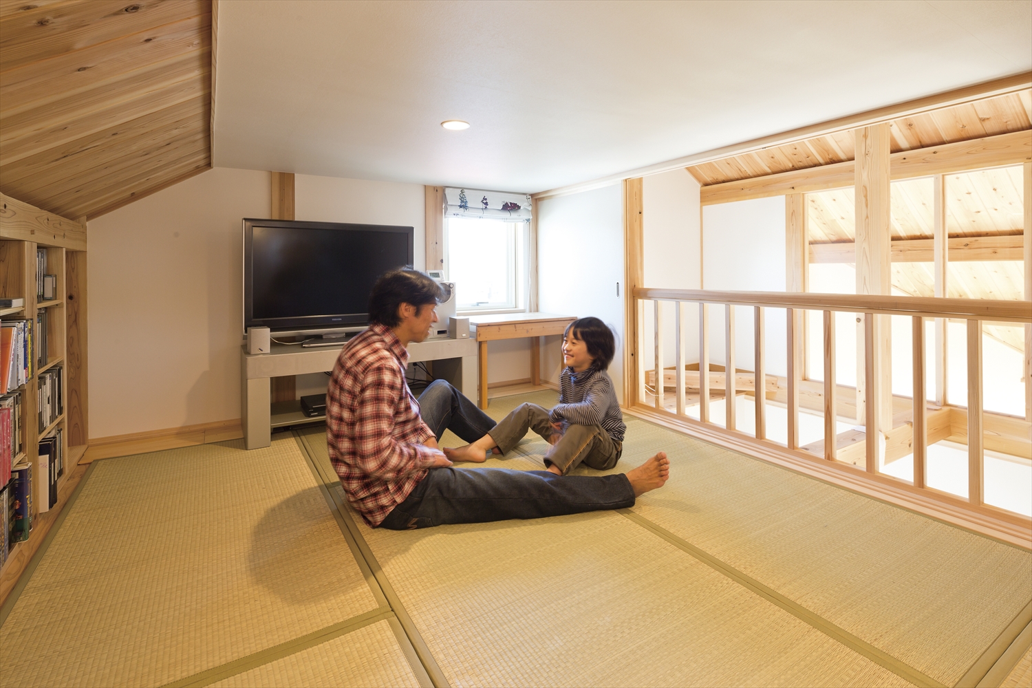 畳敷き小屋裏部屋で親子がくつろぐ様子 全館空調で快適な空間
