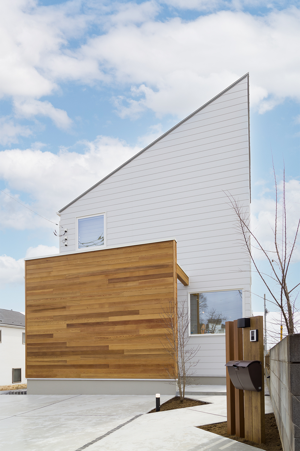 東村山市 T様邸 外壁の白を基調とした外観。天然木のアクセントと調和したスタイリッシュなファサード。