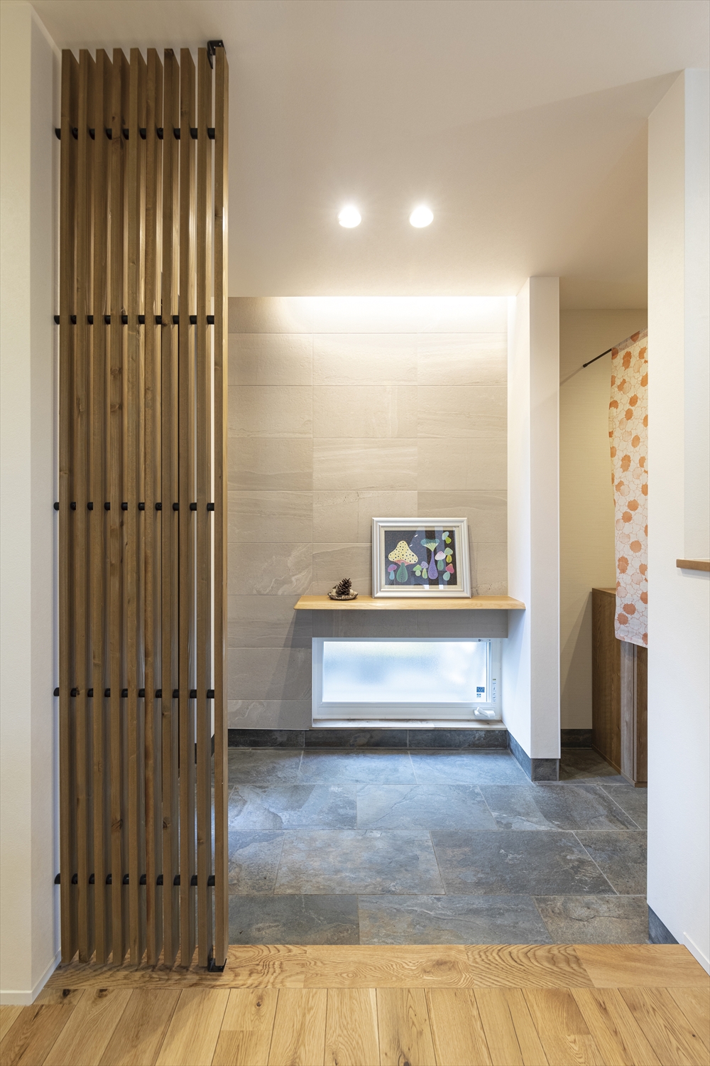 玄関土間の意匠壁と飾り棚｜タイル×間接照明で上質なお迎え