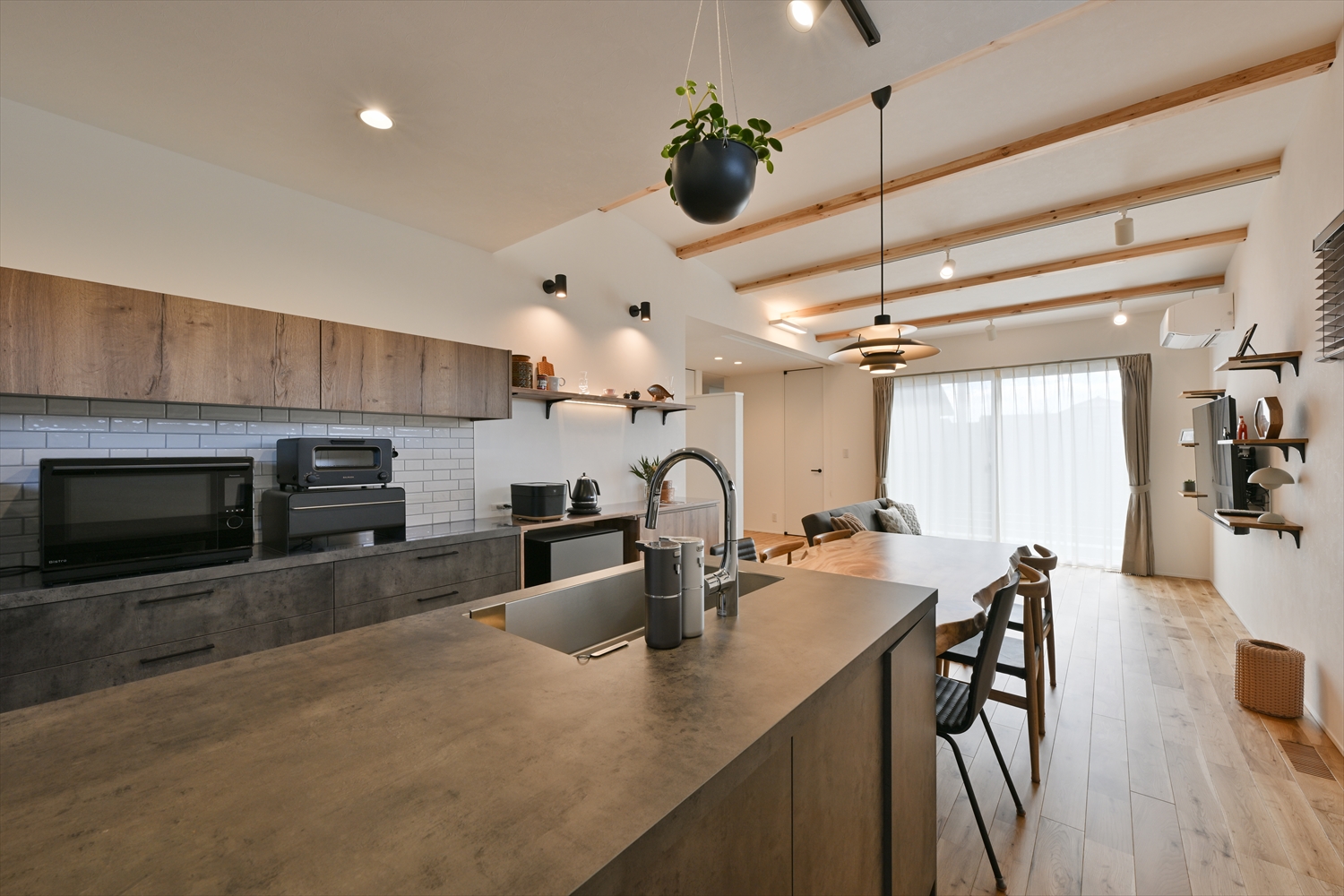 R+houseの平屋注文住宅、木目天井梁と一体感のあるグラフテクトのアイランドキッチンとダイニング