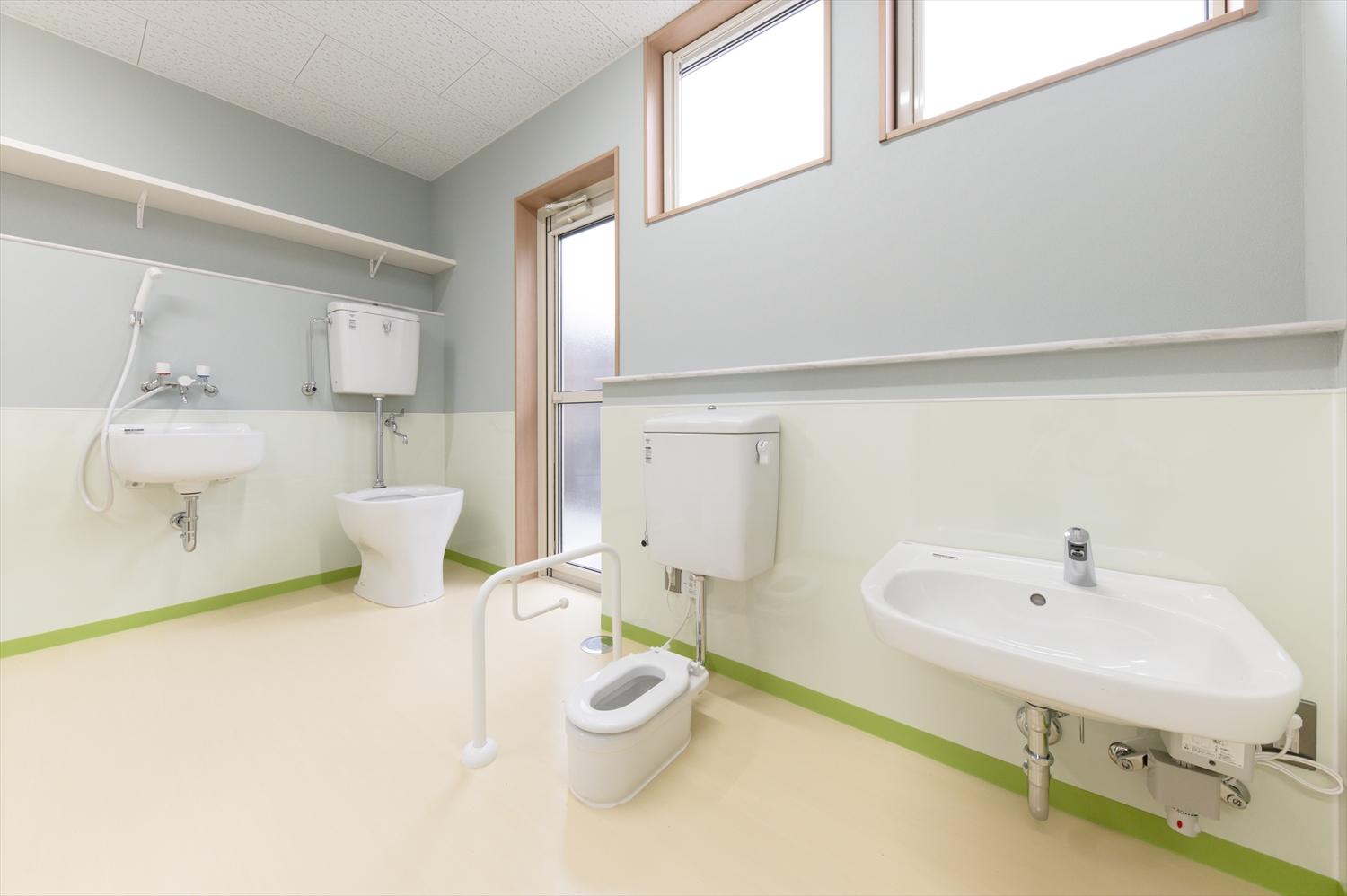 院内保育園のトイレ。子ども用サイズの便器と洗面台、明るい内装で清潔感のある衛生スペース。