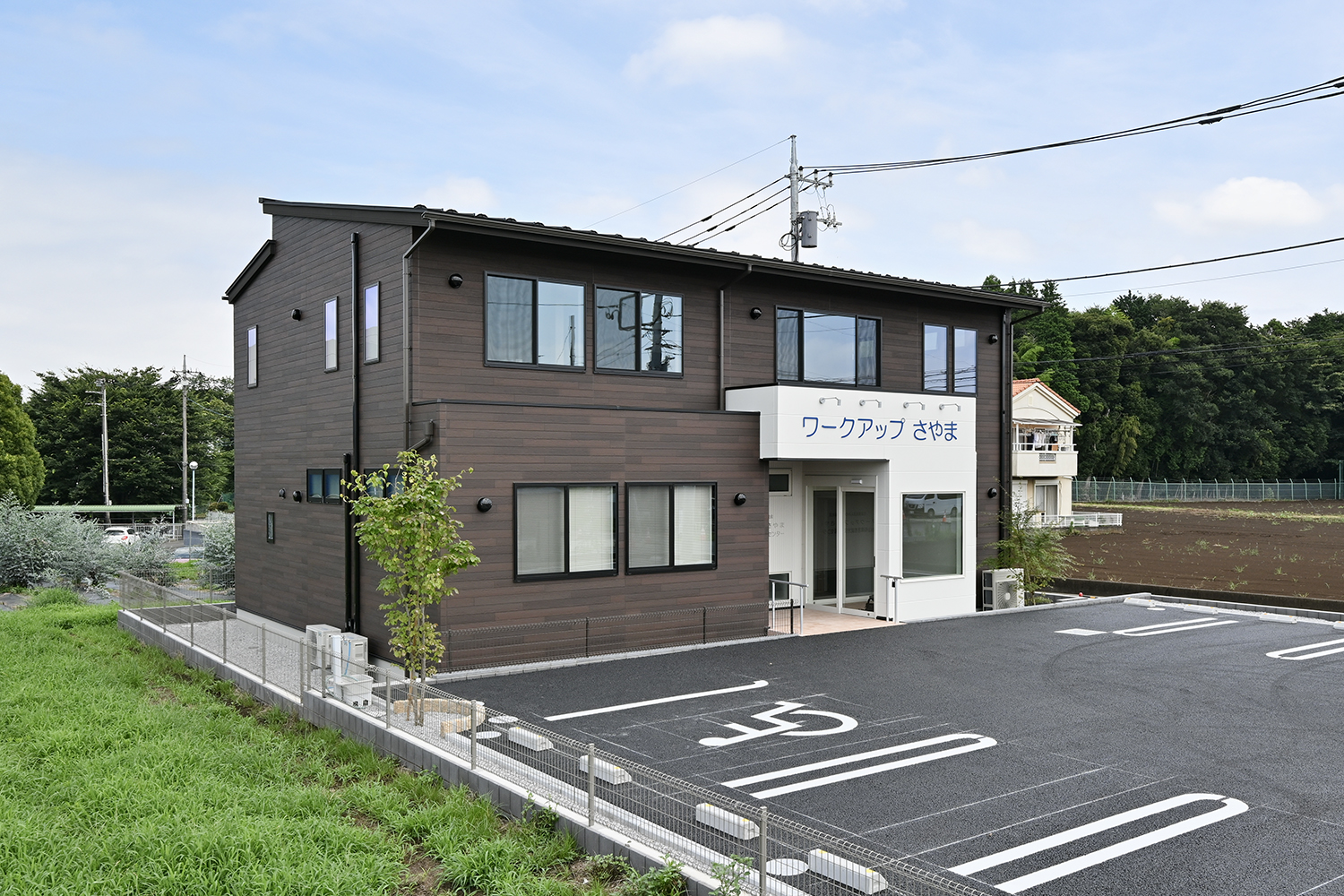 みのり福祉会ワークアップさやまの建物全景と駐車場