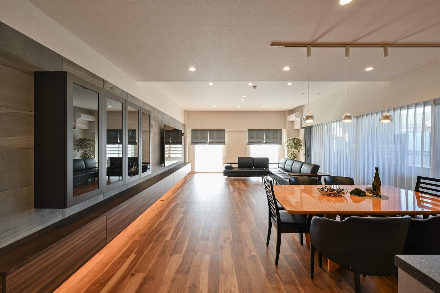 改修後のLDK（木目フローリング・ダウンライト・ダイニングとキッチン一体）