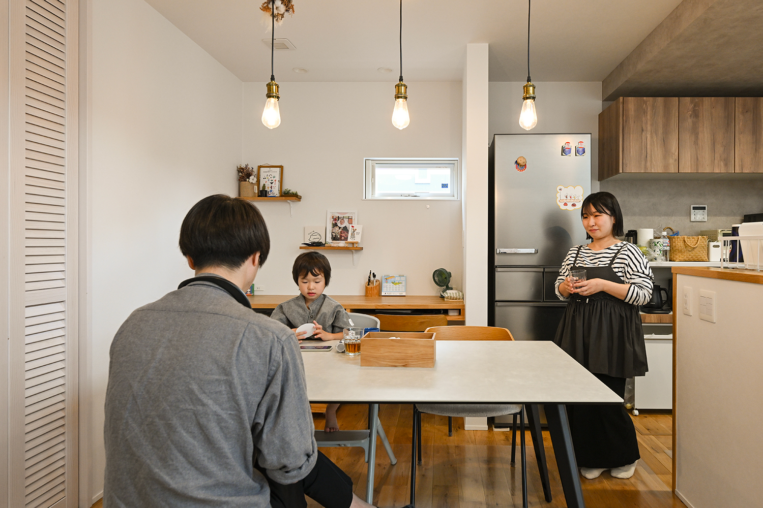 所沢市K様邸 R+house建築家住宅のダイニングキッチンでくつろぐご家族の様子
