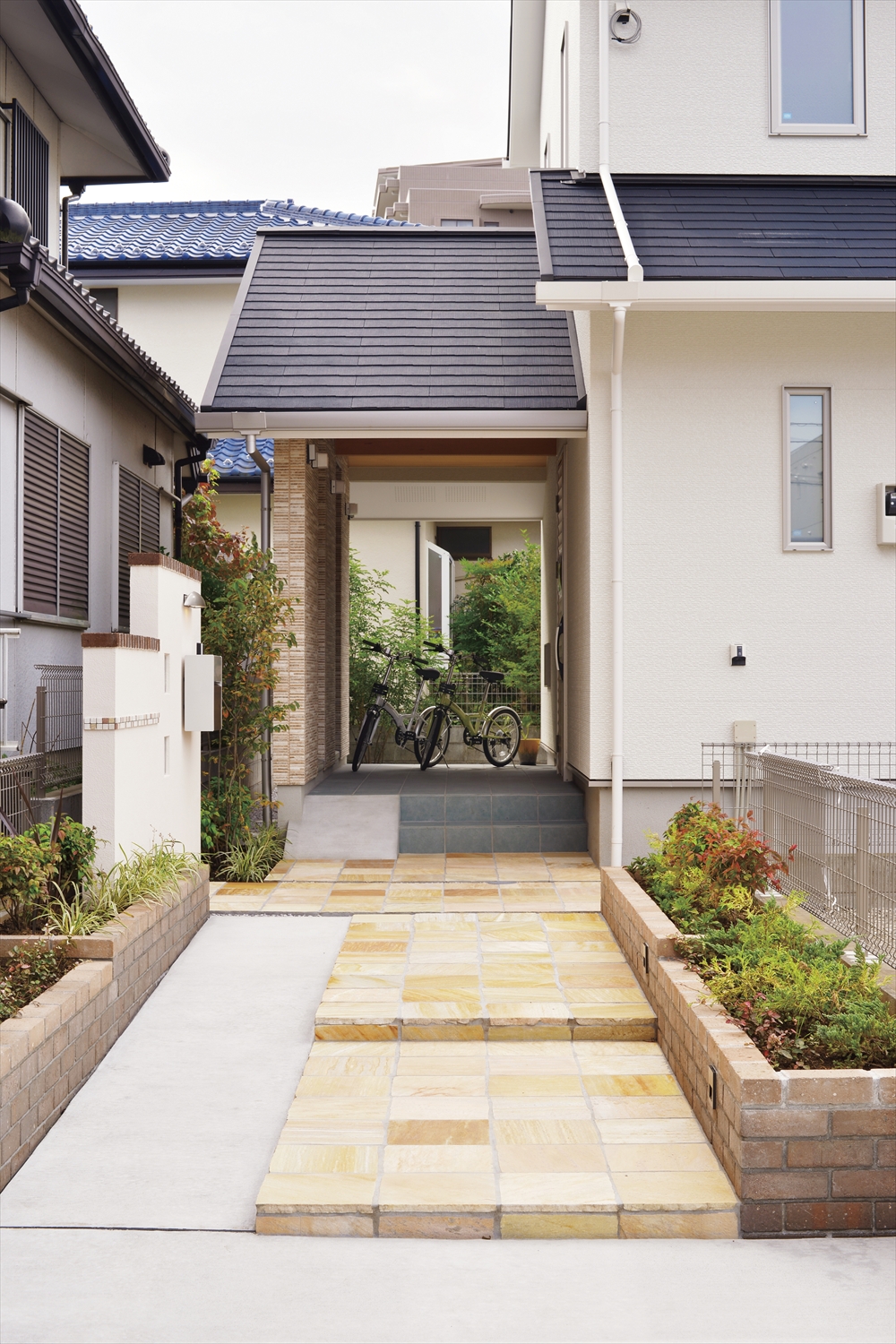 外観アプローチ/屋根付き通路と植栽のあるエントランス(埼玉県所沢市|WELL+)