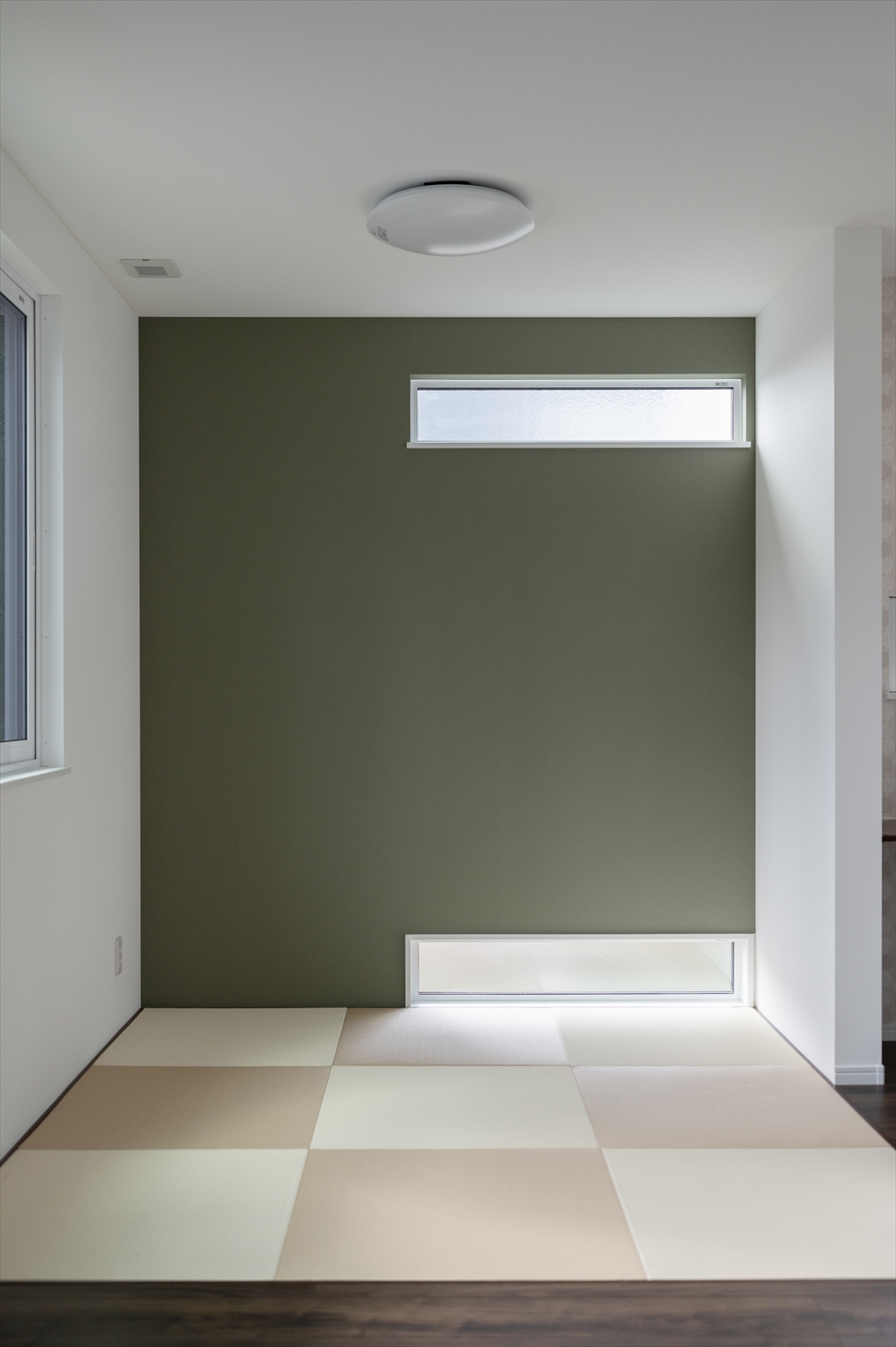 グリーンのアクセント壁と地窓・高窓のある畳スペース
