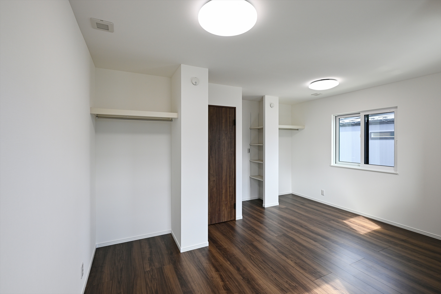 ハンガーパイプ付きのオープンクローゼットがある洋室