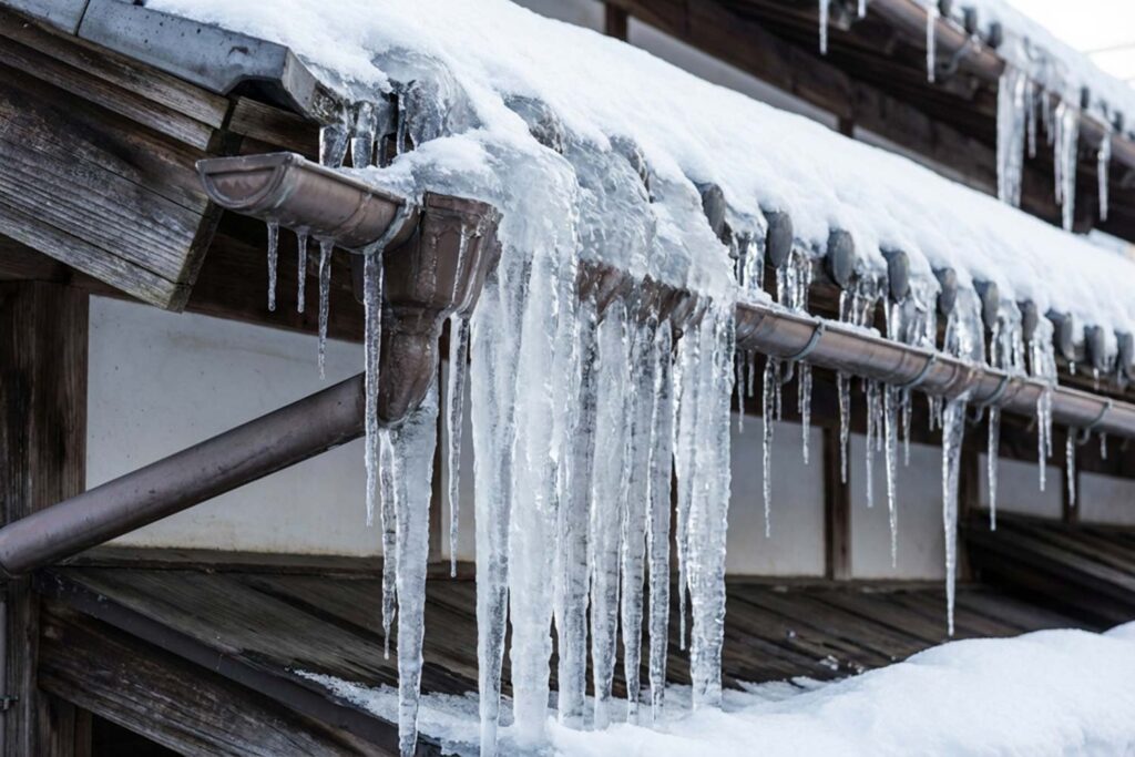 雨樋に氷が詰まり軒先にツララができた様子