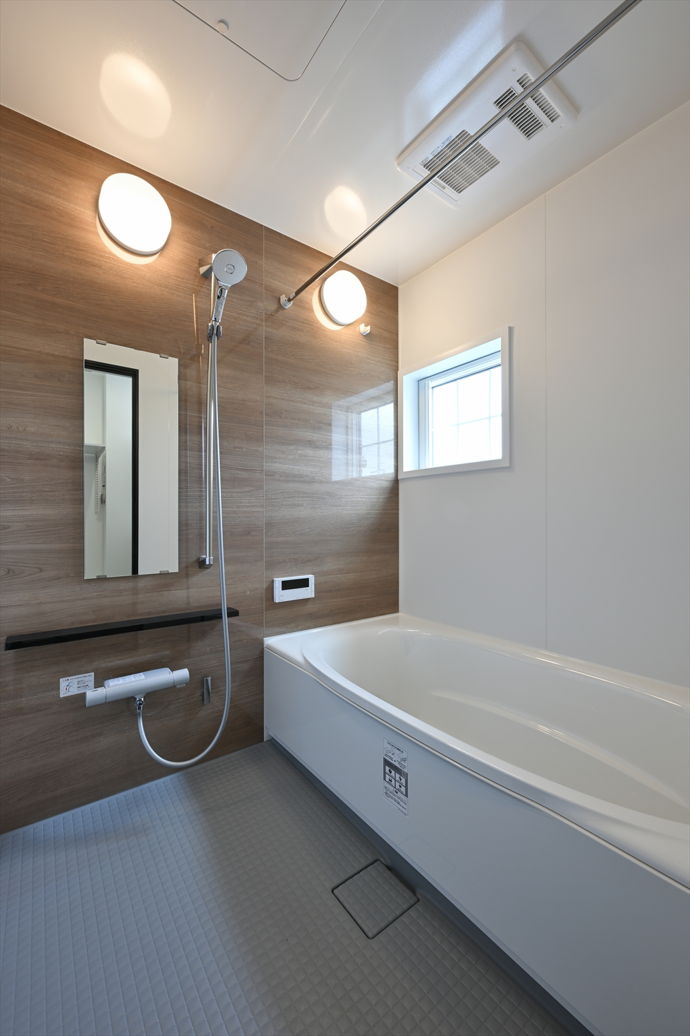 木目アクセントパネルの浴室と浴槽、換気設備