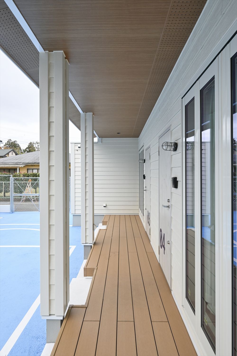 屋根付きの玄関アプローチとウッドデッキ風通路