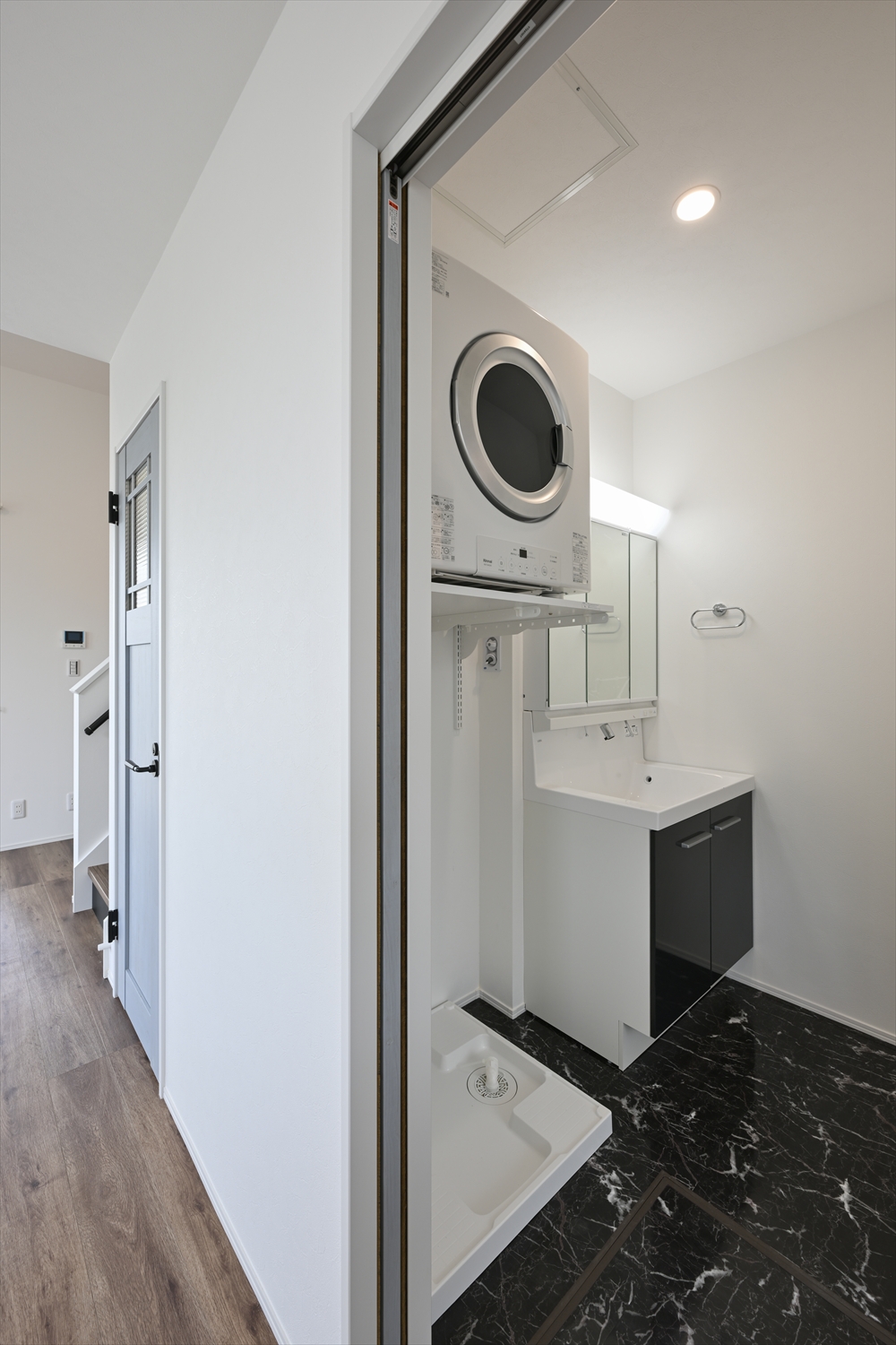 洗面台と洗濯機パン、収納棚がある洗面室