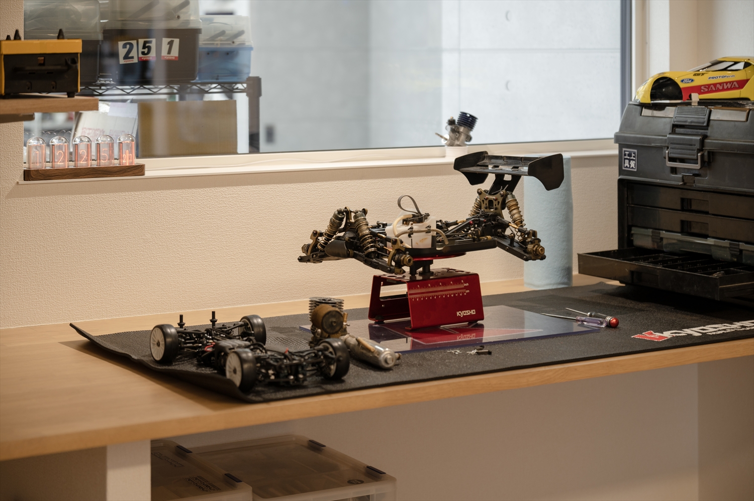 入間市のガレージハウスの趣味用作業カウンターで、ラジコンの整備を行う様子(室内窓付き)