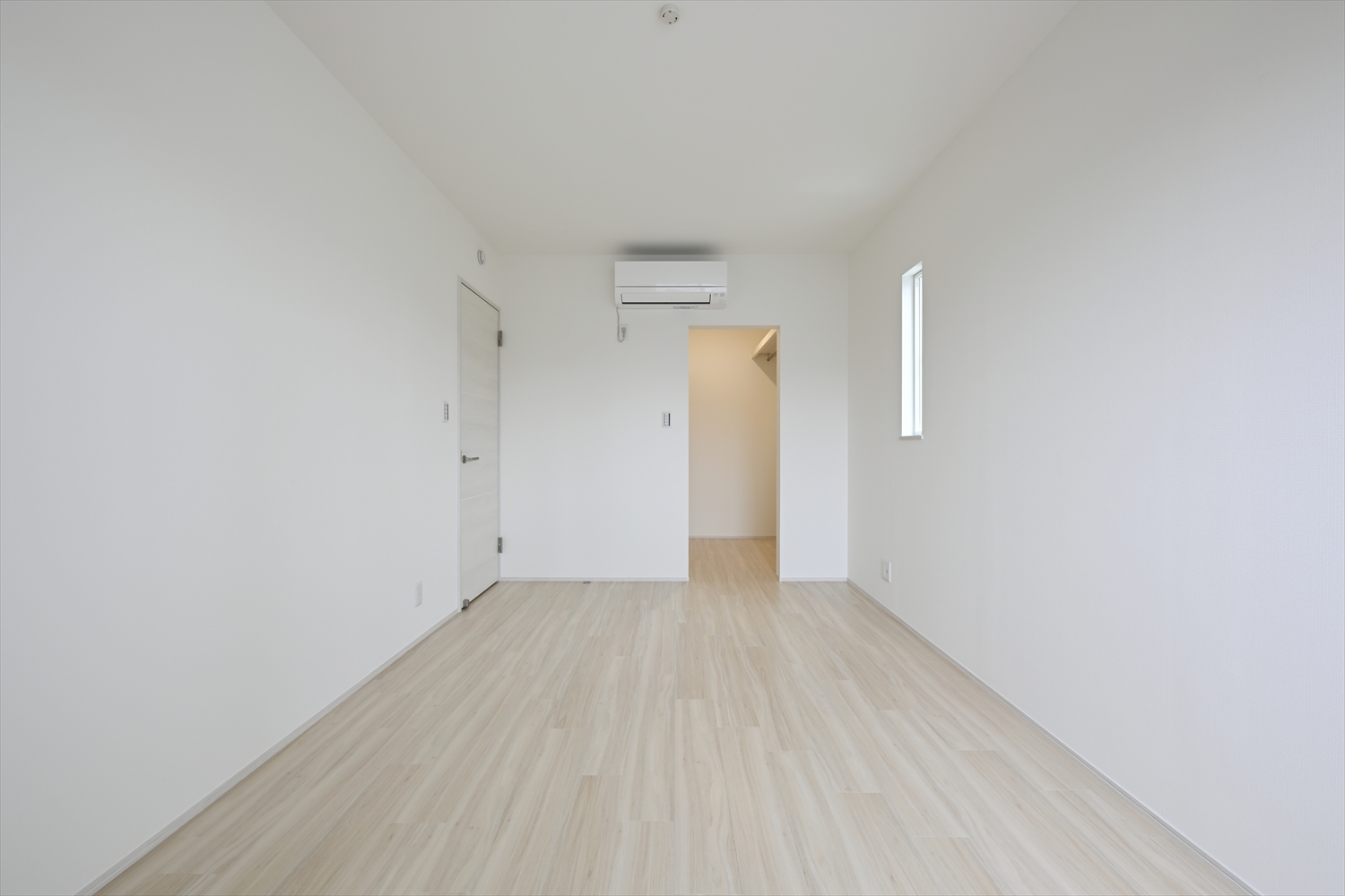 2階の洋室、エアコンと窓があるシンプルな寝室空間