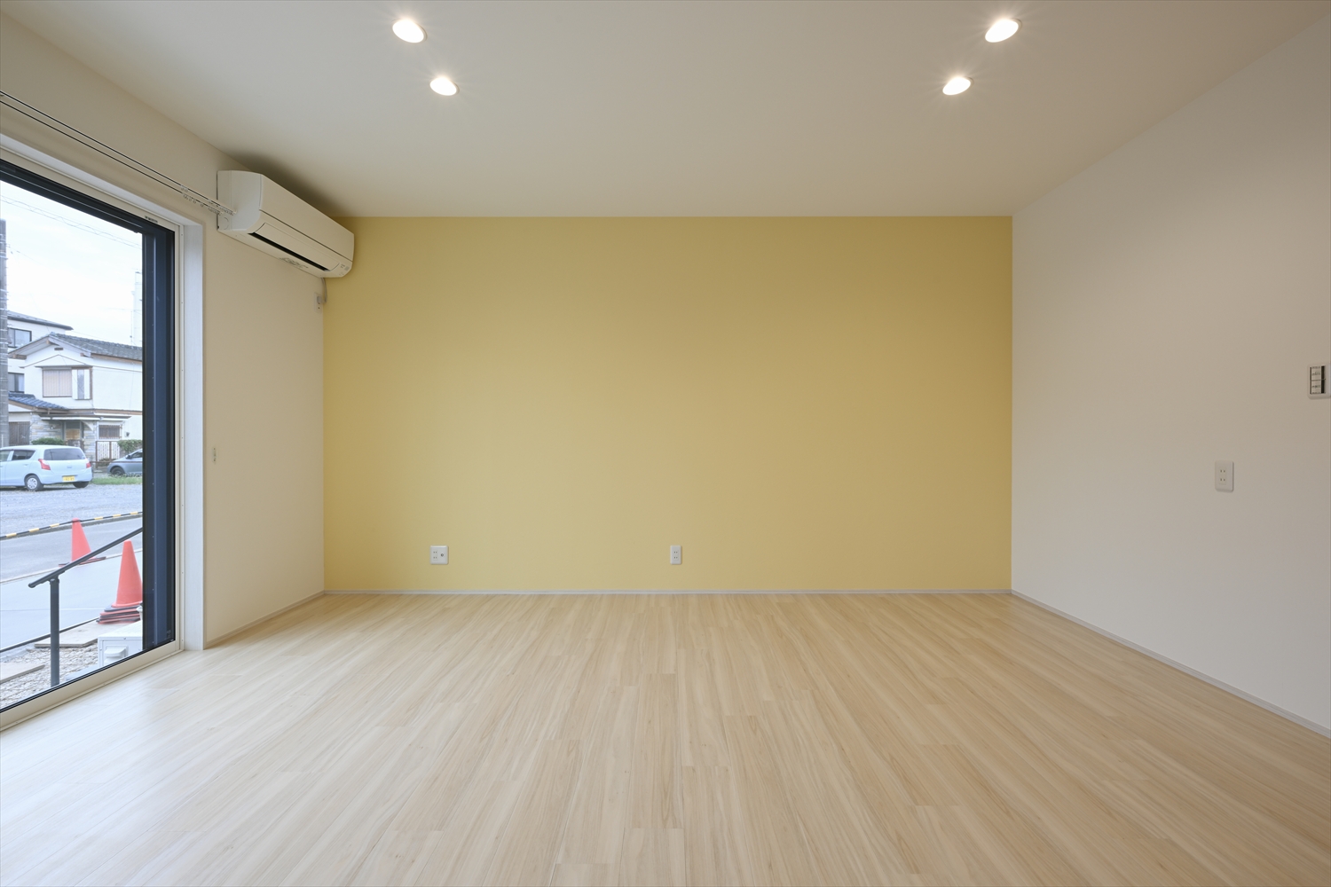 アクセントクロスのあるLDK、掃き出し窓とエアコンを備えた明るいリビング