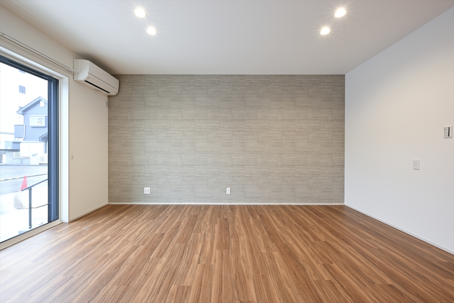 グレー系アクセントクロスのLDK、掃き出し窓があるリビング空間