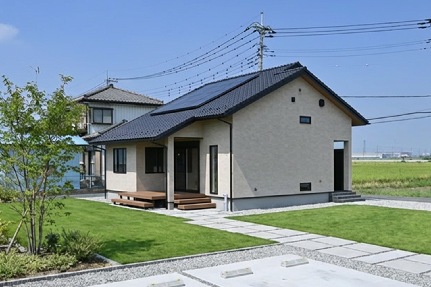 芝生の庭とウッドデッキがある外観、屋根に太陽光パネル