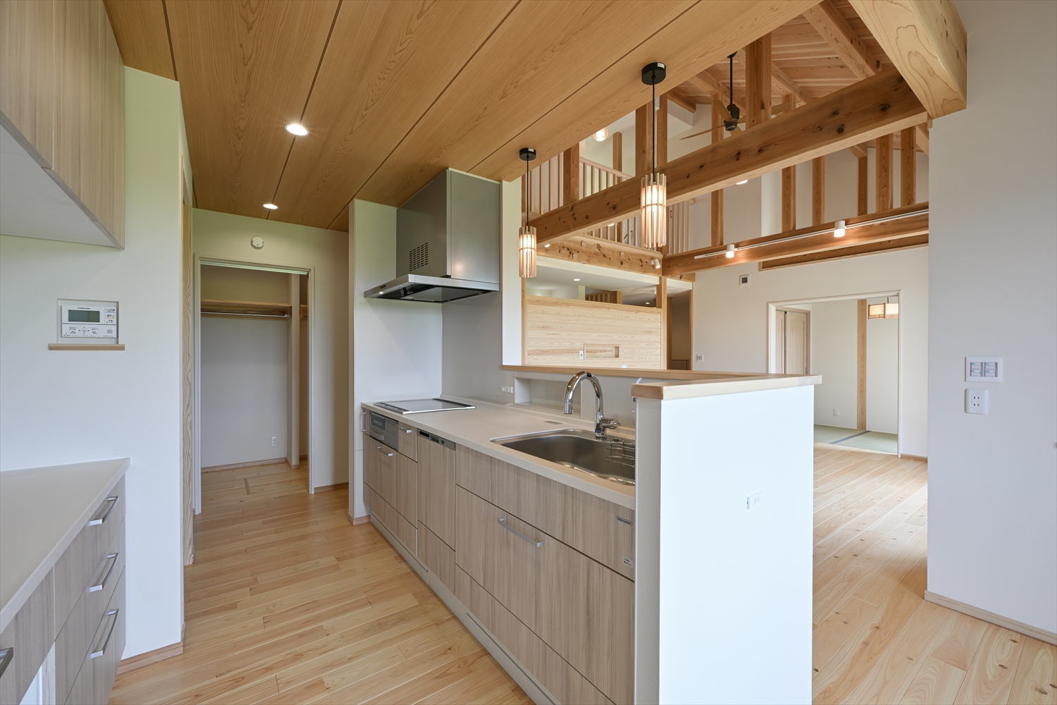 対面キッチン（ペニンシュラ）とLDK、奥にパントリー