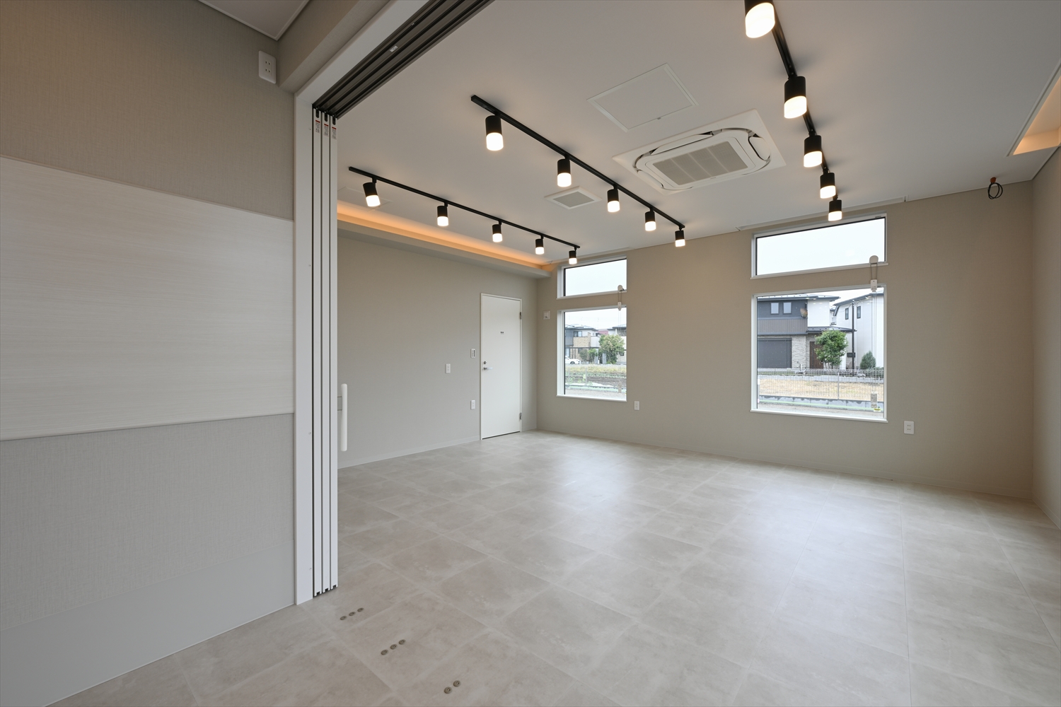 待合スペースから多目的ルームへつながる開口、広がりのある室内