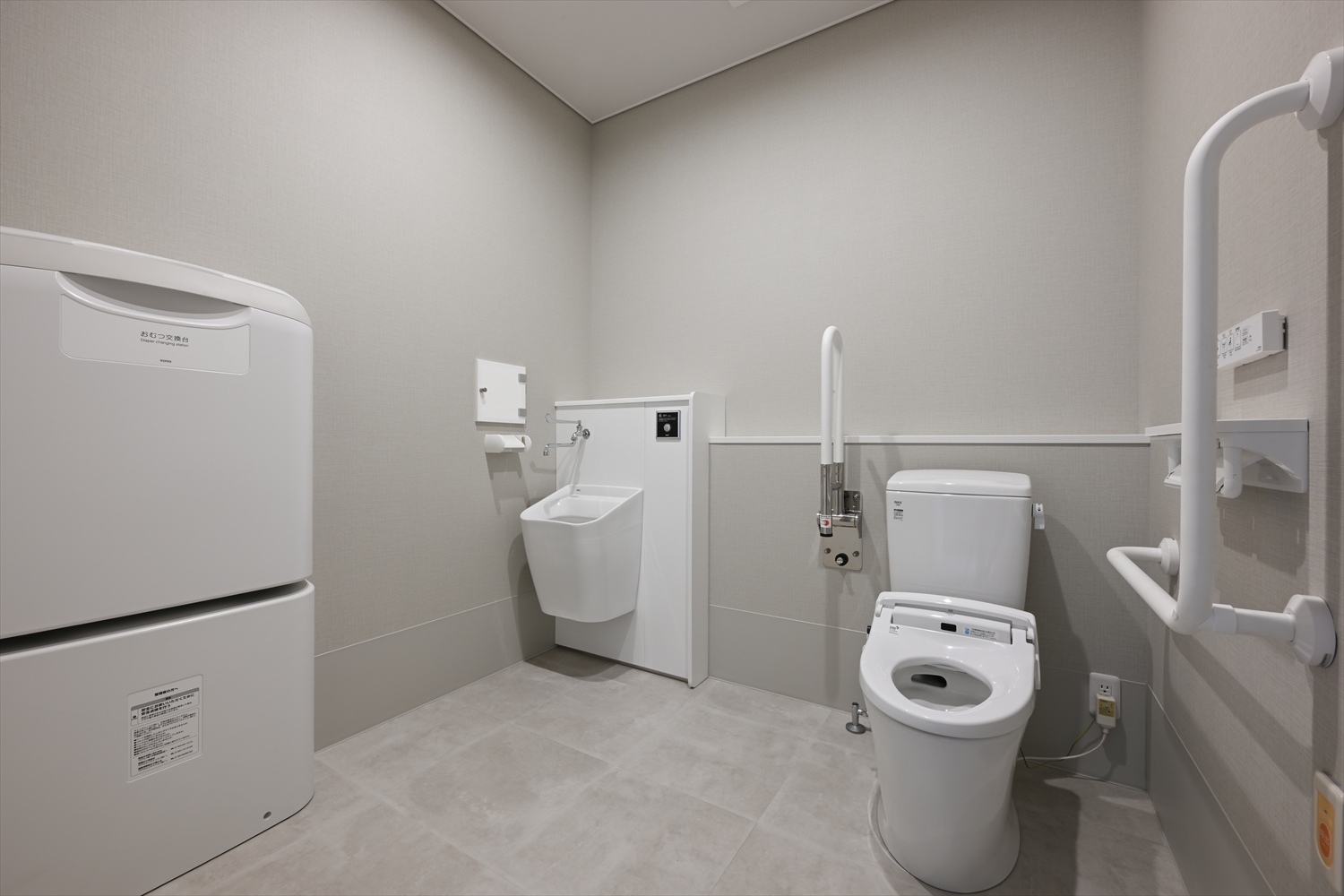 手すり付きの多機能トイレ、手洗い設備を備えた室内