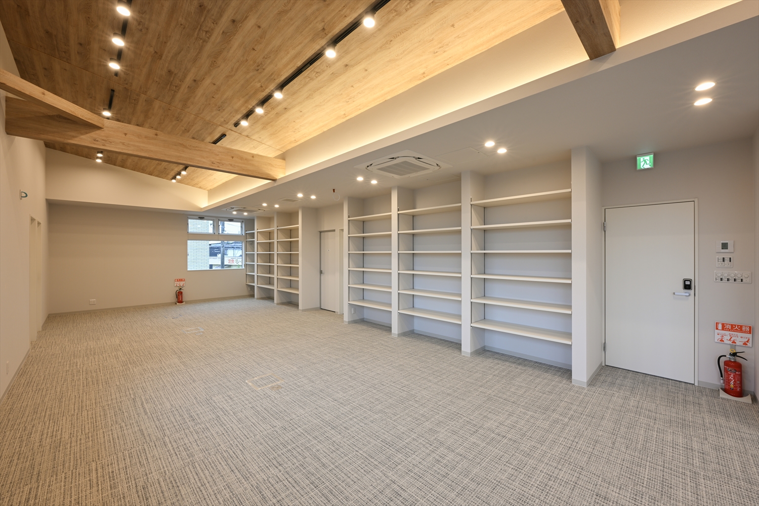 2階スタッフルームの室内、ゆとりある床面と明るい採光の空間