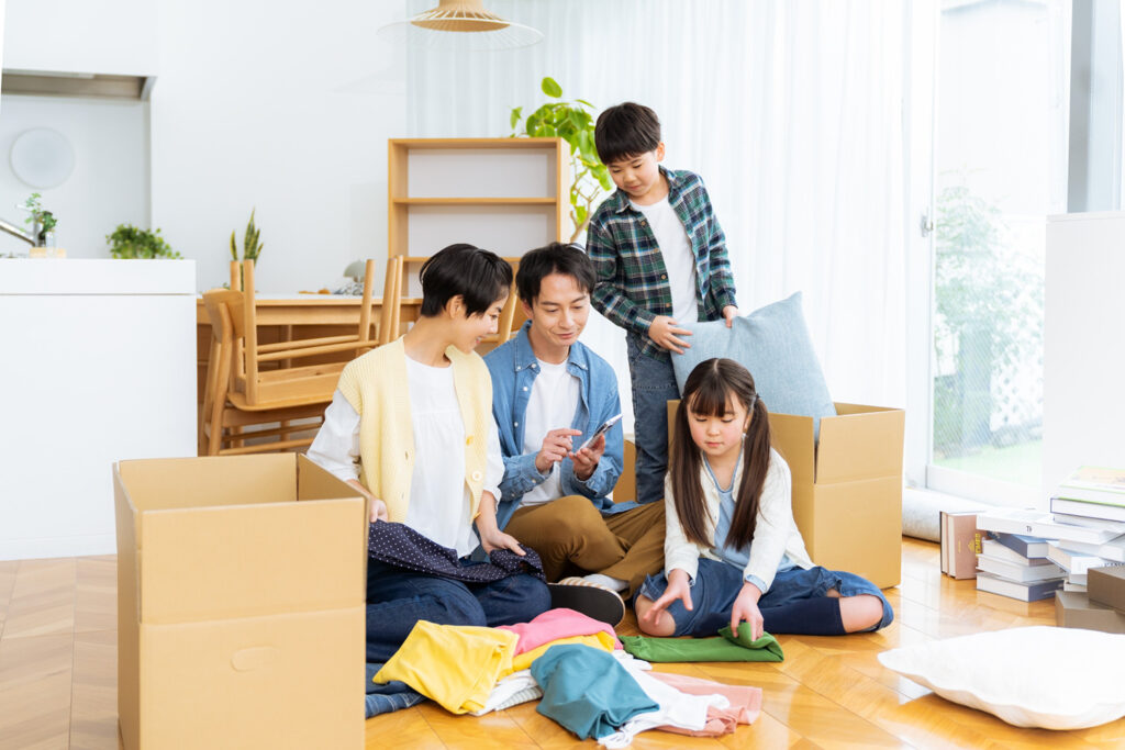段ボールとチェックリストで引越し準備をする家族
