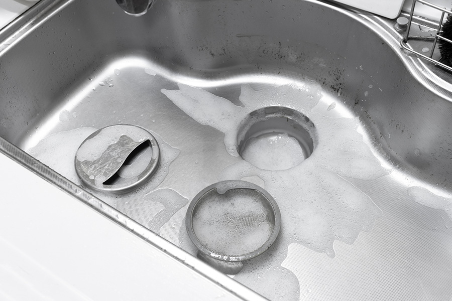 キッチンシンクの排水口まわりの様子。排水口部品を外して、汚れがたまりやすい部分を確認しているイメージ