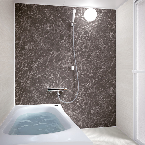 TOTO WTシリーズNタイプ（マンション用浴室・1216）の施工イメージ。石目調のアクセントパネルと浴槽で、限られたスペースでも快適に整う浴室リフォーム