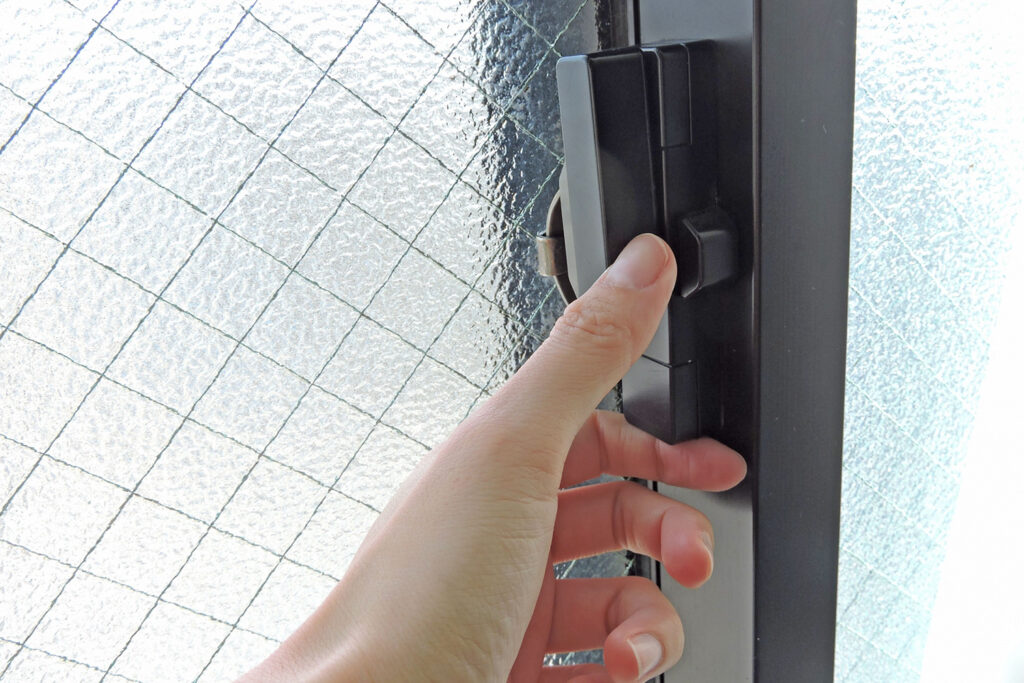 窓のクレセント錠(締まり金具)を確認している様子