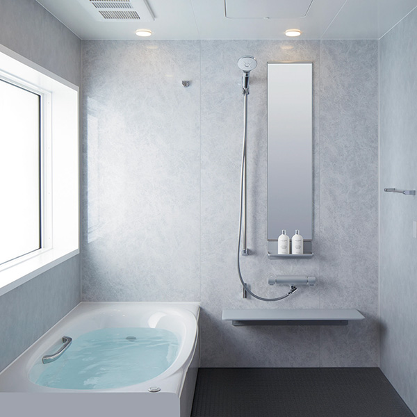 LIXILのシステムバス「AX」（S1216）の施工イメージ。グレーの壁面と黒い床で、すっきりとした印象の浴室