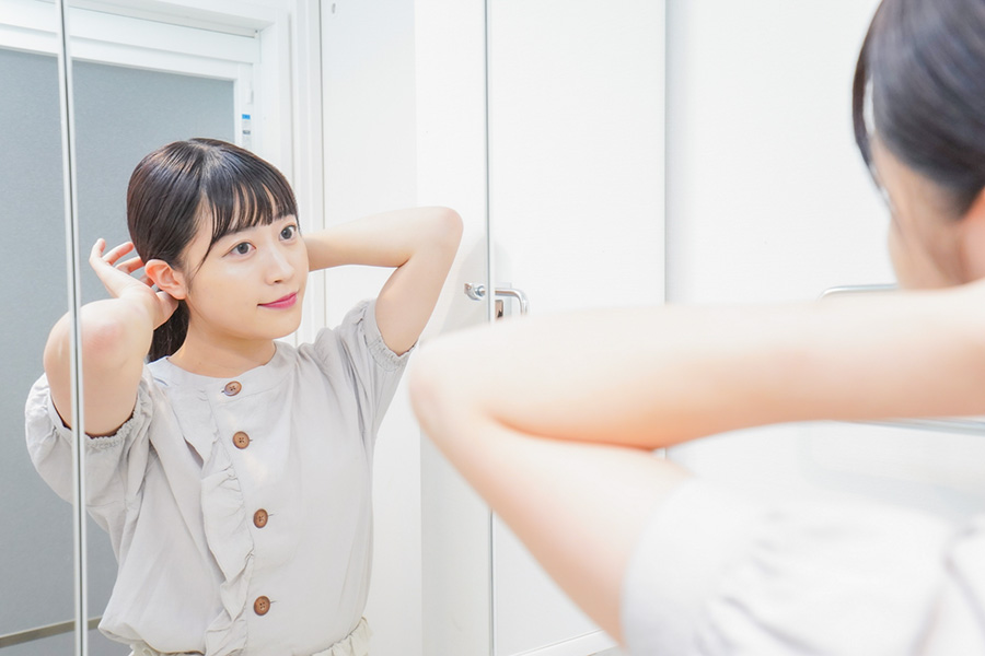 鏡の前で髪を整える女性の身支度の様子