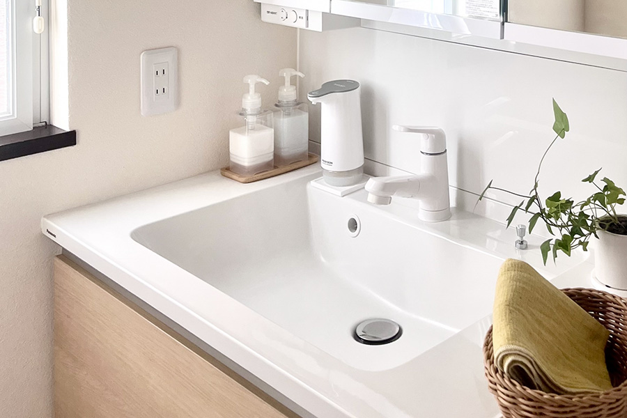 白いボウル一体型洗面台と水栓まわり。清潔感のある洗面スペースのイメージ