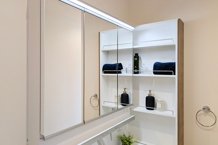 三面鏡の洗面化粧台と棚収納で、タオルや小物が整理された洗面スペース
