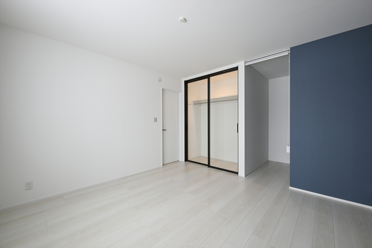 主寝室の透明ガラス引違い戸のクローゼット（内部ダウンライトでショールームのように演出）