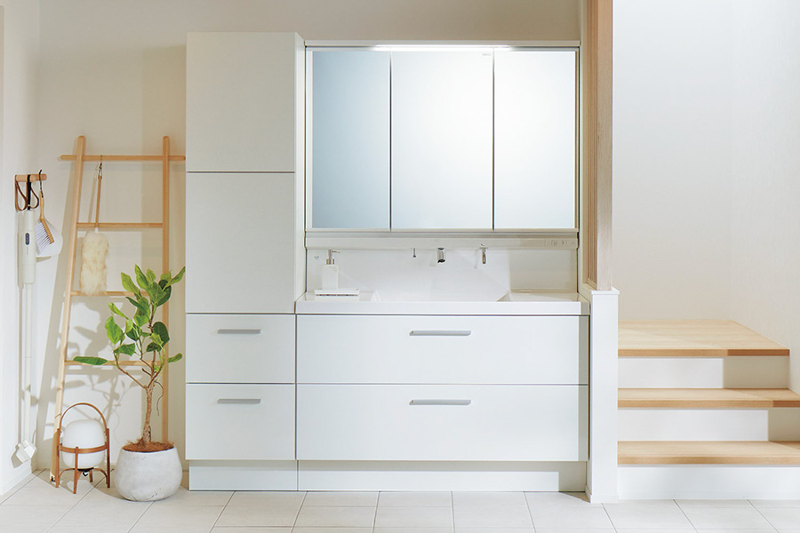 三面鏡と引き出し収納を備えた白い洗面化粧台。明るくすっきりした洗面スペースのイメージ