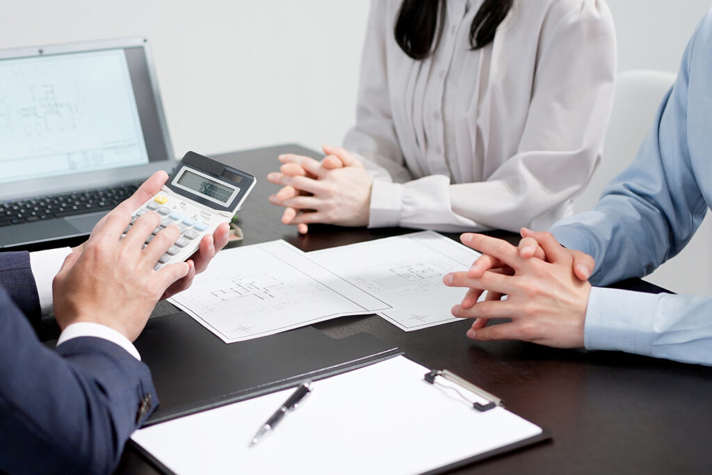 注文住宅の見積書を見ながら総額を確認する家族
