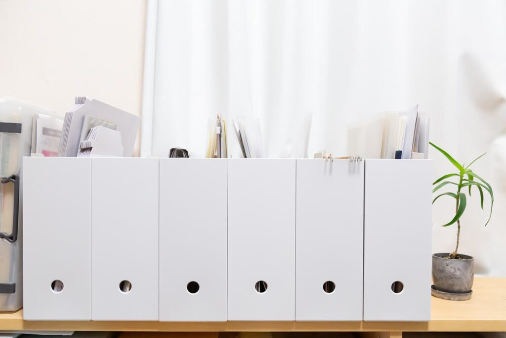 AdobeStock_1901066159 | アップルホーム リビング近くにある家族共有収納で子どもの作品を整理するイメージ