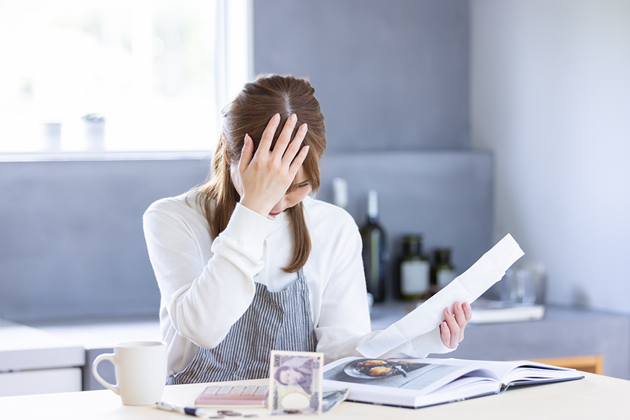 光熱費の明細を見て悩む様子（断熱リフォームで省エネを目指すイメージ）