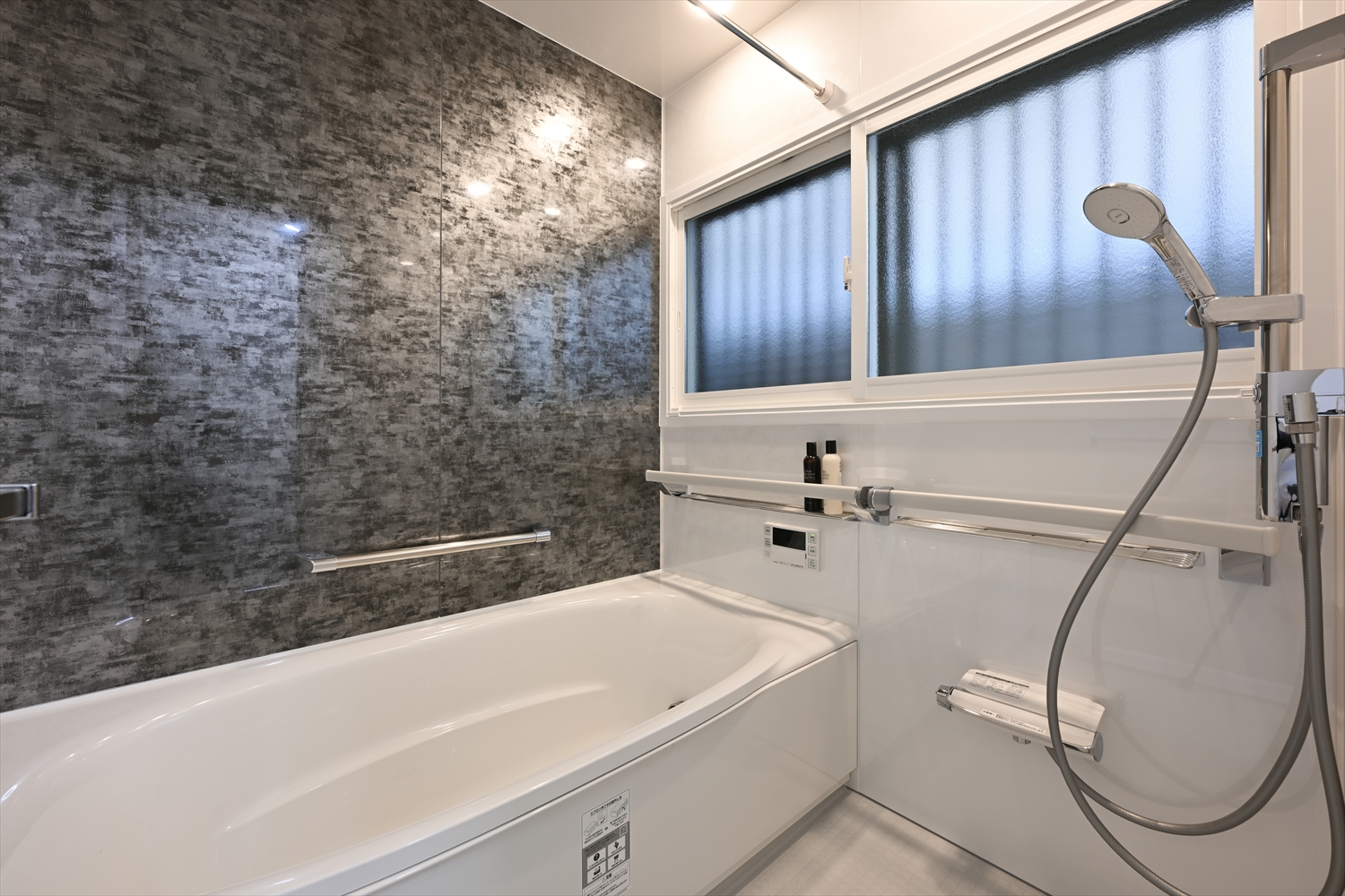 ブラックアクセントパネルが映えるリノベーション後の浴室