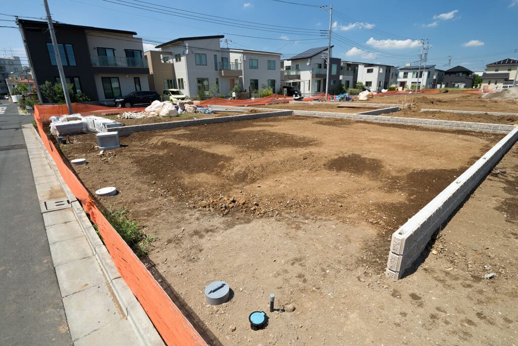 売地の境界標と隣地との境界線を確認する様子