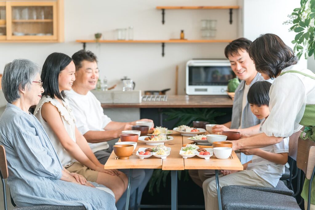 二世帯住宅の間取りと共有範囲を家族で話し合うイメージ