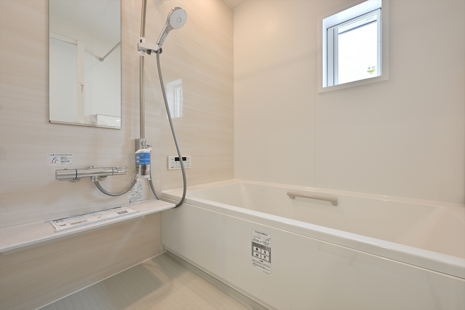 明るい浴室と浴室換気乾燥暖房機を備えたバスルーム