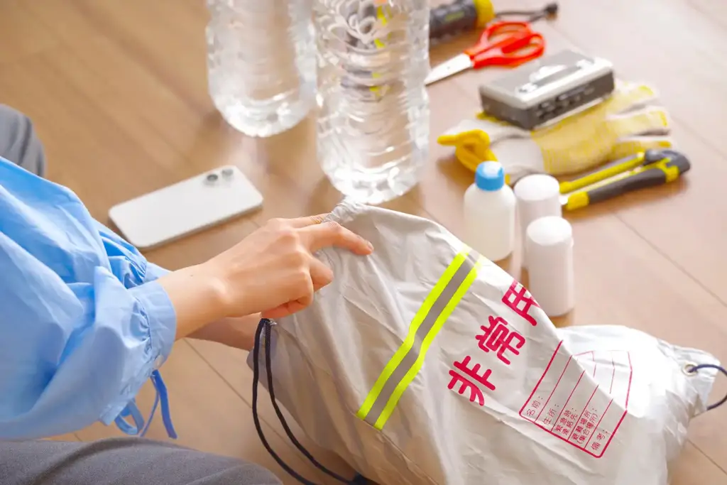 住宅アドバイザーと家族が図面を見ながら、災害時の生活動線・備蓄収納・設備計画を確認している様子。 | アップルホーム 注文住宅のレジリエンス設計で災害時の備えを家族で確認する様子