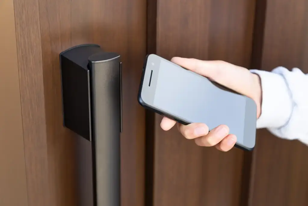 玄関ドアのスマートキー操作部を確認する住宅の玄関