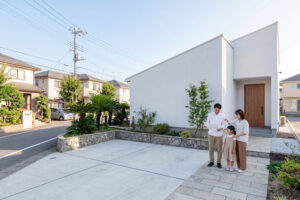 新築住宅の前で外構計画を考える家族