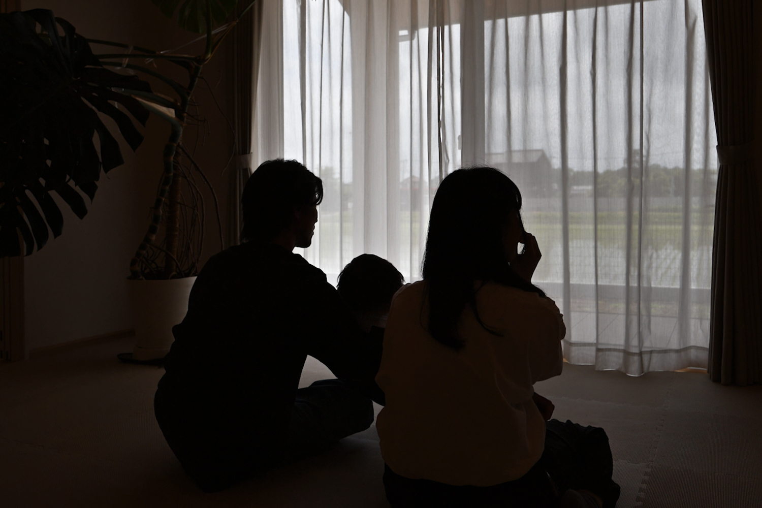 窓辺でくつろぐWELL+のお施主様ご家族のシルエット|猫と暮らす1.5階平屋のオーナーズインタビュー