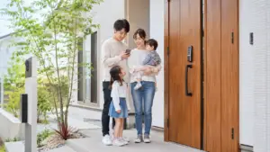注文住宅の玄関でスマートロックを操作する家族