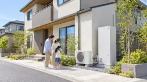 注文住宅の外壁脇に設置したエコキュートを家族で確認する様子